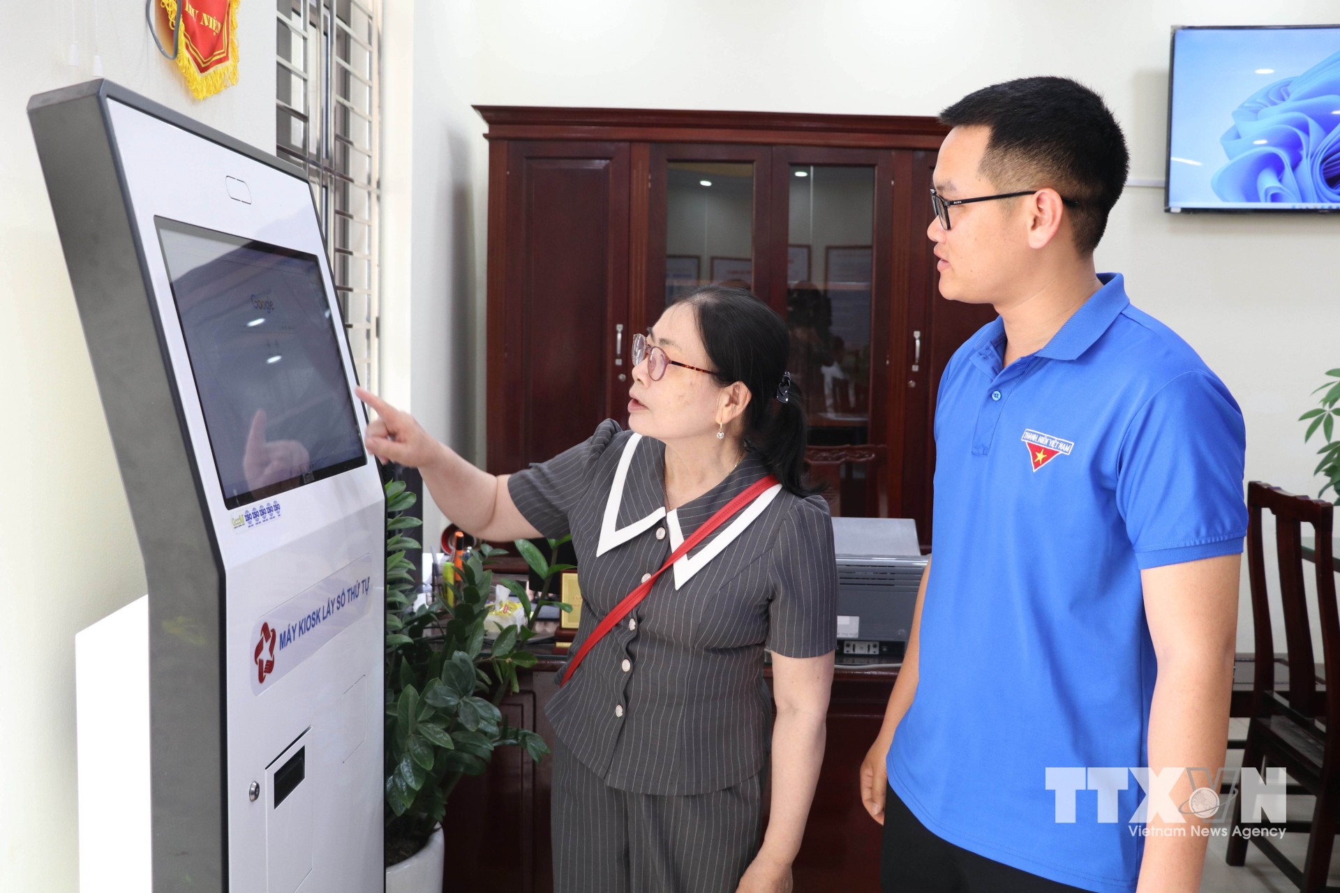 Đoàn viên thanh niên hướng dẫn người dân sử dụng dịch vụ công trực tuyến tại Trung tâm Phục vụ hành chính công xã Giao Bình, tỉnh Ninh Bình. (Ảnh: Thùy Dung/TTXVN)